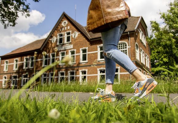 Person geht auf einem Bürgersteig vor dem Bürogebäude