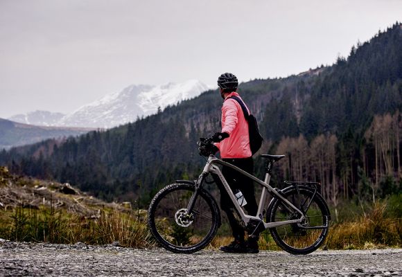 Eine Person steht mit einem Kalkhoff Fahrrad in den Bergen.