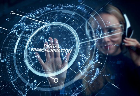 Eine Frau mit Headset berührt eine holographische Darstellung mit dem Text "Digital Transformation".