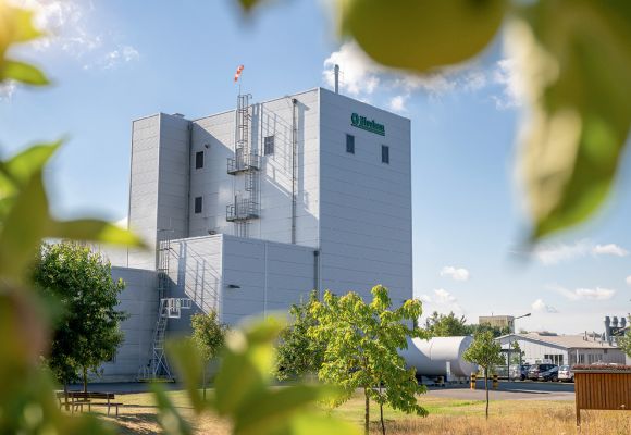 Produktionsanlage zwischen Grünflachen bei Sonnenschein